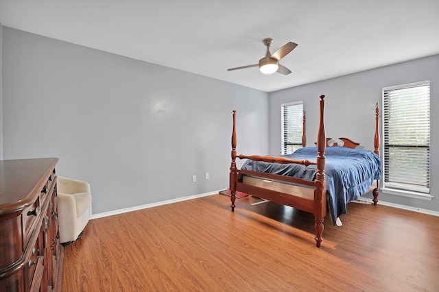 bedroom featuring multiple windows, ceiling fan, and hardwood / wood-style flooring