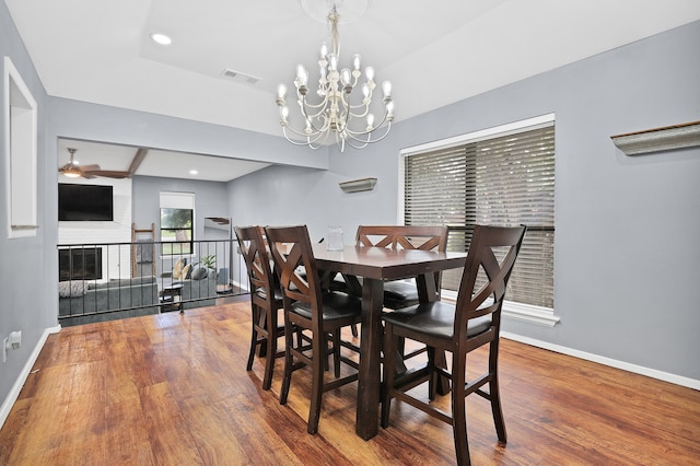 dining area featuring hardwood / wood-style floors and ceiling fan with notable chandelier