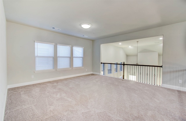 empty room featuring light carpet and vaulted ceiling