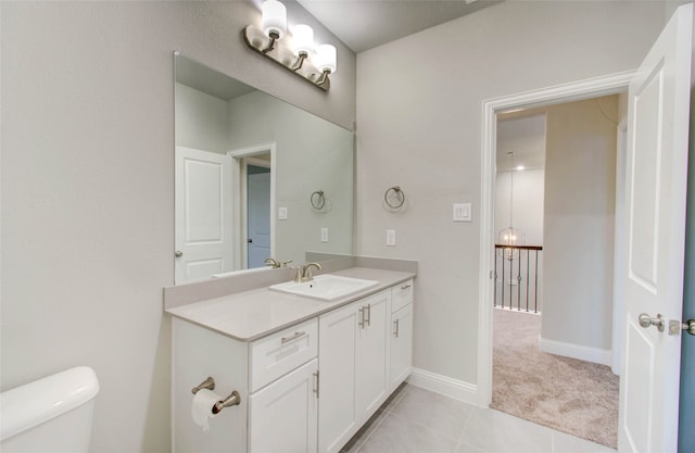 bathroom with toilet, vanity, and tile patterned floors