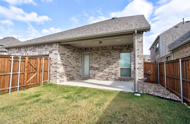 rear view of house featuring a patio area and a lawn