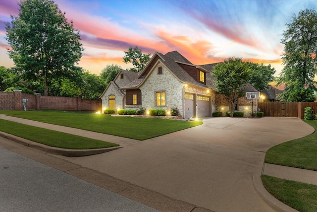 french country inspired facade featuring a lawn and a garage