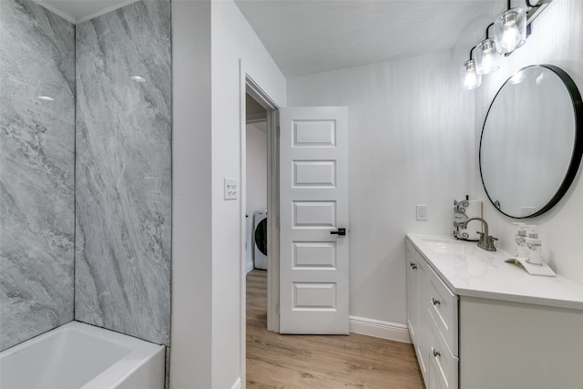 bathroom featuring vanity, washer / clothes dryer, wood-type flooring, and a washtub