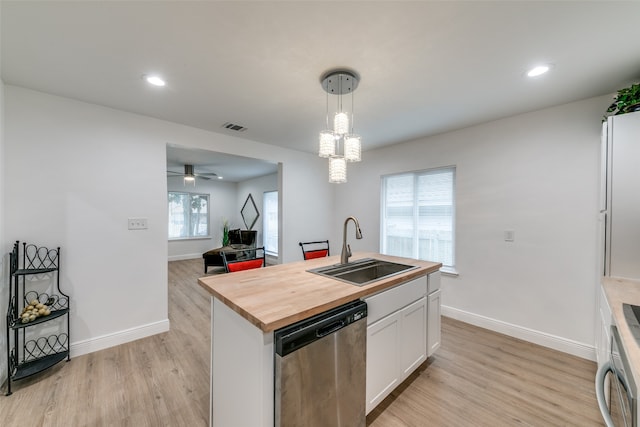 kitchen featuring hanging light fixtures, white cabinetry, a kitchen island with sink, stainless steel dishwasher, and sink