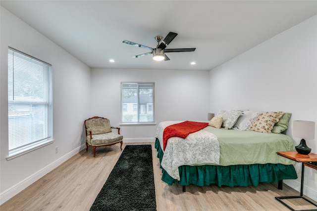 bedroom featuring multiple windows, light wood-type flooring, and ceiling fan