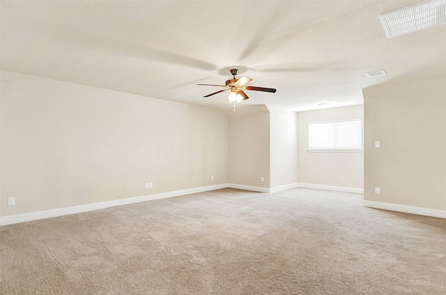 spare room with light carpet, ceiling fan, and a textured ceiling