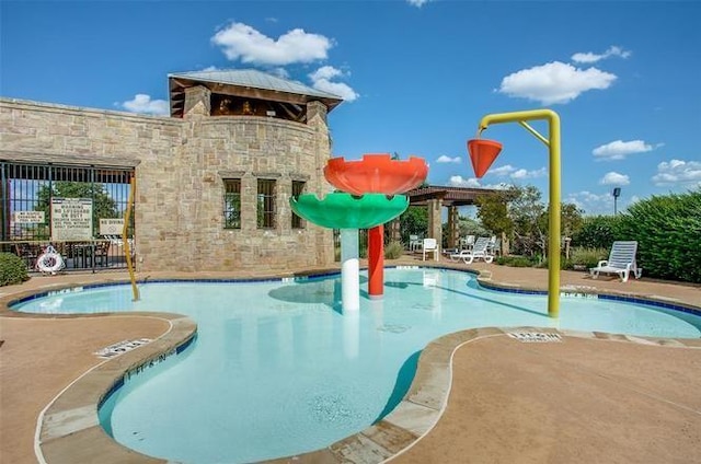 view of pool featuring a water slide and a patio area