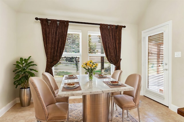 dining area with lofted ceiling and light tile patterned floors