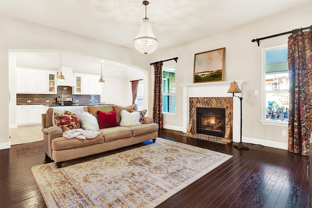 living room featuring a high end fireplace and dark hardwood / wood-style floors