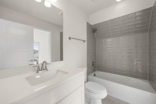 full bathroom featuring tiled shower / bath, vanity, tile patterned floors, and toilet