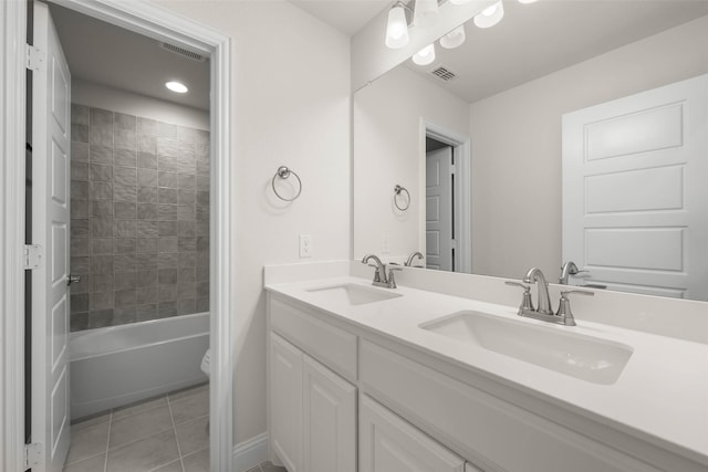 full bathroom featuring tile patterned flooring, vanity, tiled shower / bath, and toilet