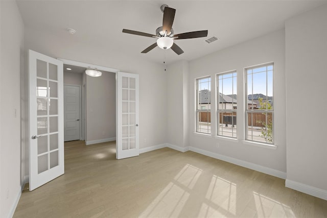 unfurnished room featuring ceiling fan, light hardwood / wood-style floors, and french doors