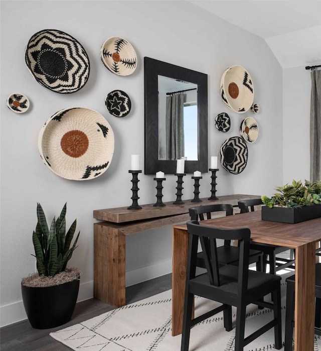 dining area featuring wood-type flooring and lofted ceiling