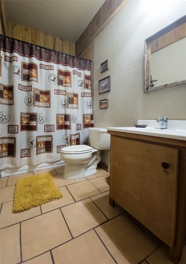 bathroom featuring toilet, curtained shower, vanity, and tile patterned flooring