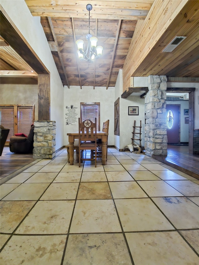 unfurnished dining area featuring beamed ceiling, decorative columns, a notable chandelier, and wooden ceiling