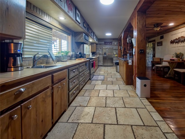 kitchen with sink, appliances with stainless steel finishes, light hardwood / wood-style floors, and ceiling fan