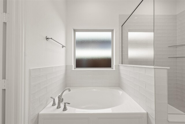 full bathroom featuring a garden tub and tiled shower