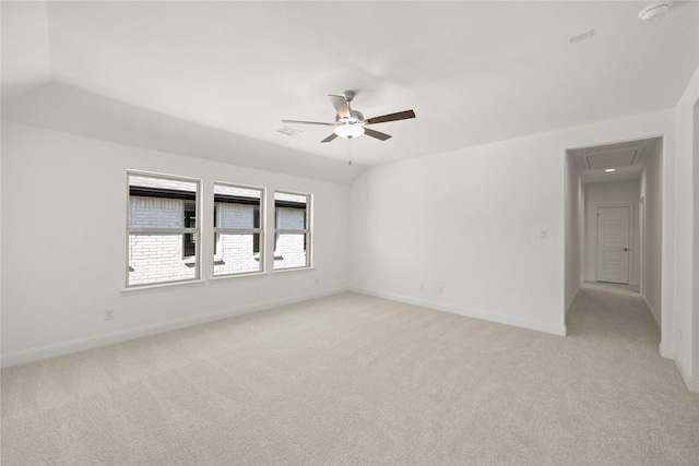 spare room with lofted ceiling, ceiling fan, baseboards, and light colored carpet