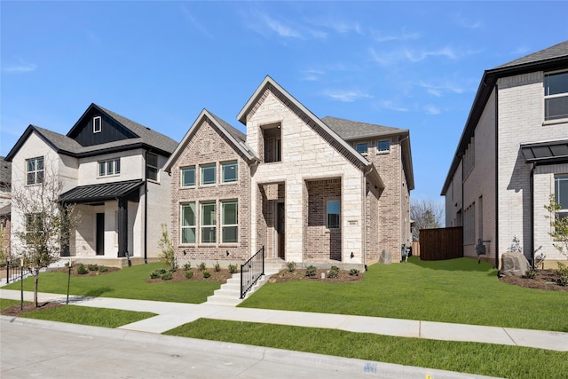 view of front facade with a front yard, stone siding, and brick siding