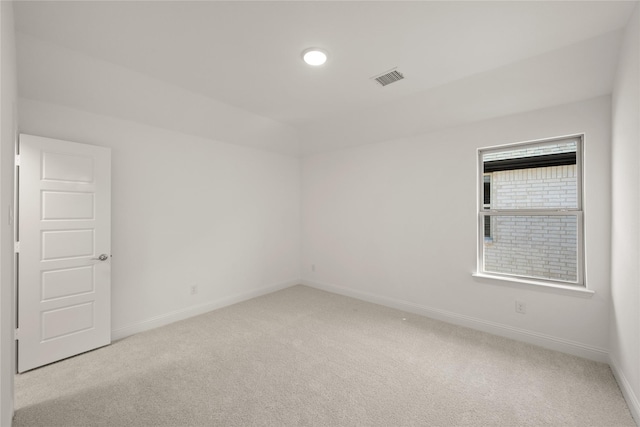 carpeted empty room featuring visible vents and baseboards