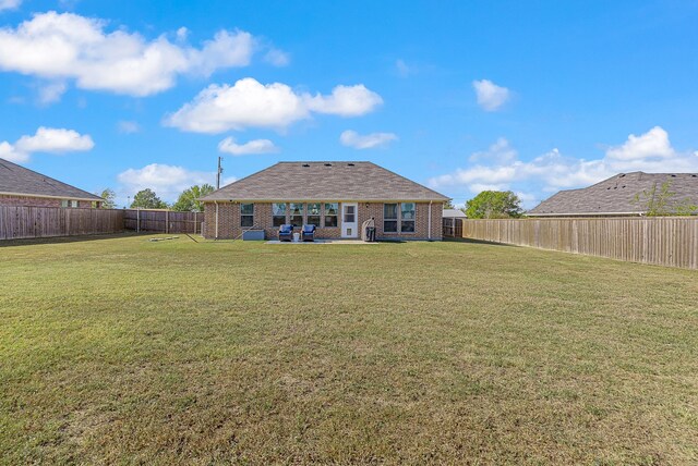 back of property featuring a patio area and a yard