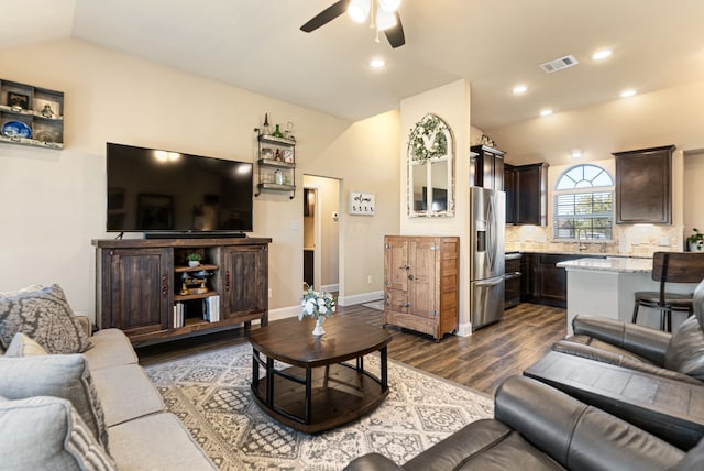 living room with baseboards, visible vents, dark wood finished floors, ceiling fan, and vaulted ceiling