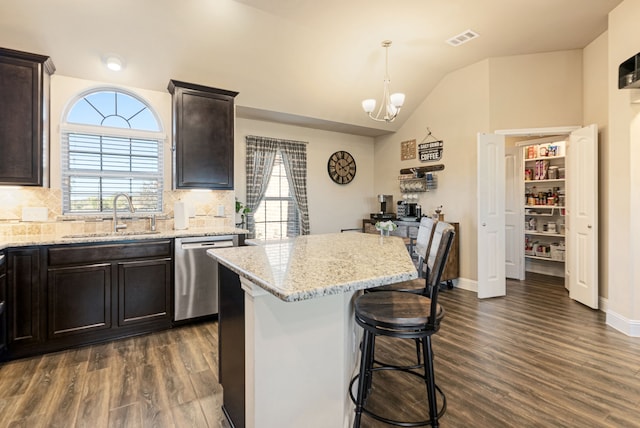 kitchen with hanging light fixtures, sink, dark hardwood / wood-style flooring, stainless steel dishwasher, and tasteful backsplash