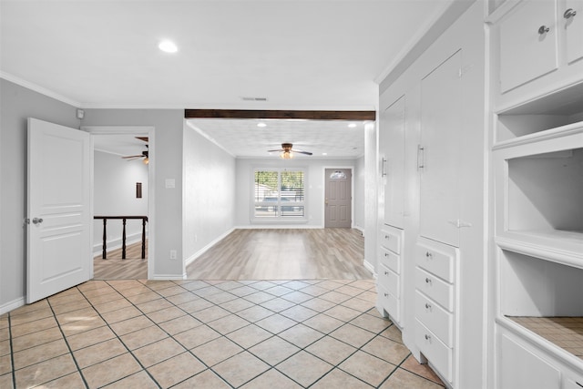 unfurnished room with beamed ceiling, light tile patterned floors, and ceiling fan