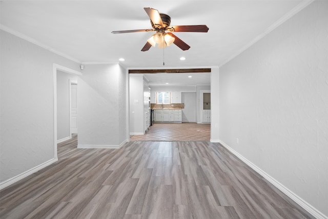 unfurnished living room featuring ceiling fan, ornamental molding, and light wood-type flooring