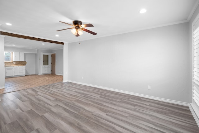 unfurnished living room featuring crown molding, ceiling fan, and light wood-type flooring