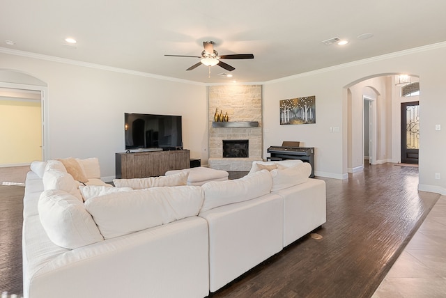 living room with ceiling fan, a fireplace, crown molding, and hardwood / wood-style flooring