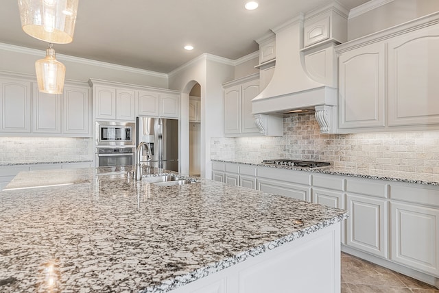 kitchen featuring decorative backsplash, white cabinets, custom range hood, and stainless steel appliances