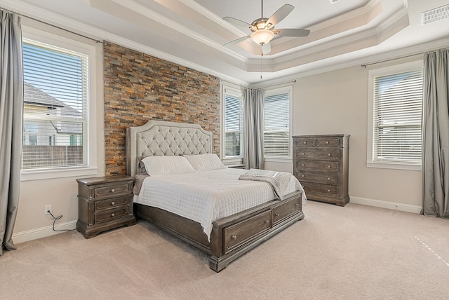 carpeted bedroom featuring ceiling fan, a raised ceiling, and multiple windows