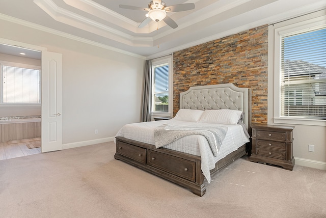 carpeted bedroom with ceiling fan, crown molding, and a tray ceiling