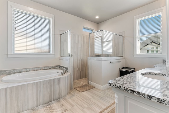 bathroom featuring plenty of natural light, vanity, and independent shower and bath