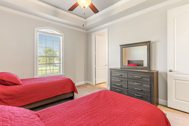 carpeted bedroom with ceiling fan, ornamental molding, and a raised ceiling