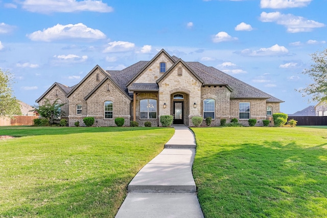 french country inspired facade featuring a front yard