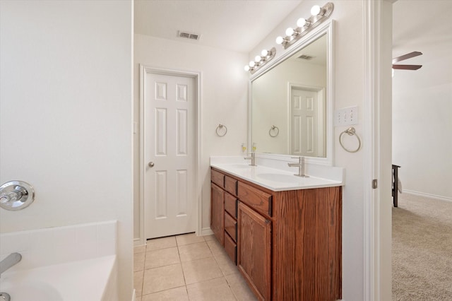 bathroom with tile patterned flooring, vanity, a bathtub, and ceiling fan