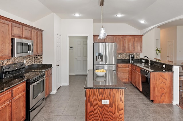 kitchen featuring kitchen peninsula, appliances with stainless steel finishes, backsplash, and hanging light fixtures