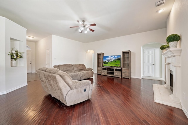 living room featuring ceiling fan and dark hardwood / wood-style flooring