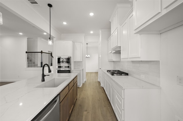 kitchen featuring light stone countertops, white cabinets, and sink