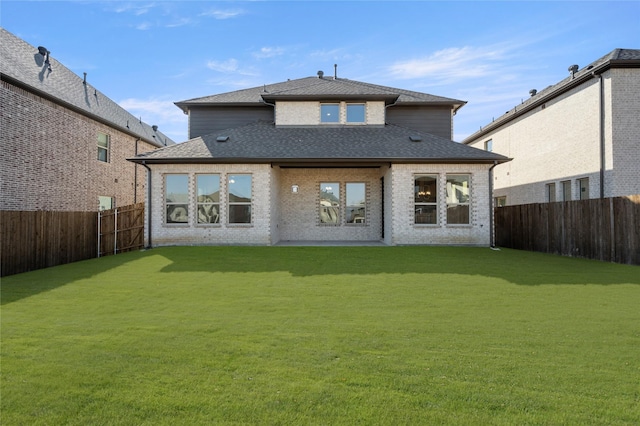 rear view of house featuring a lawn