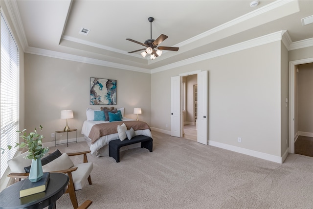 bedroom featuring light carpet, a tray ceiling, ceiling fan, and crown molding