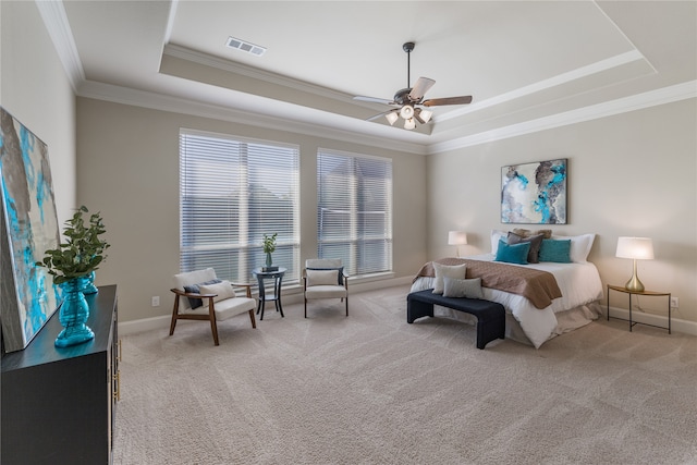 carpeted bedroom featuring a tray ceiling, ceiling fan, and ornamental molding