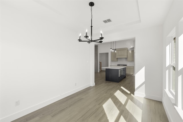 interior space with a chandelier, visible vents, baseboards, and wood finished floors