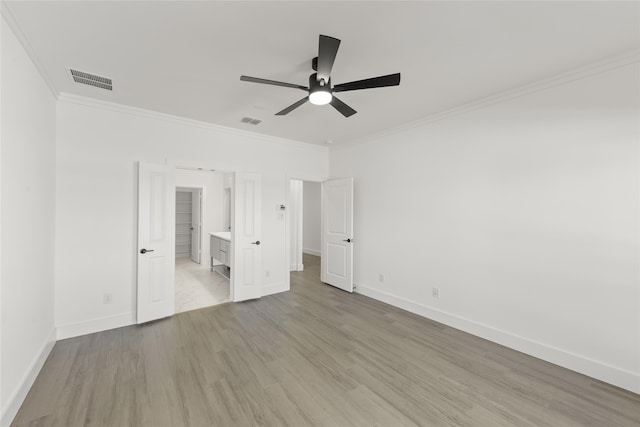 unfurnished bedroom with ornamental molding, visible vents, light wood-style flooring, and baseboards