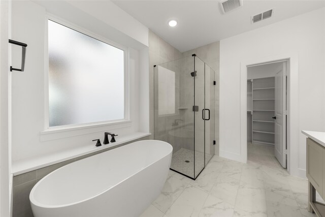 full bath featuring a stall shower, marble finish floor, visible vents, and a freestanding tub
