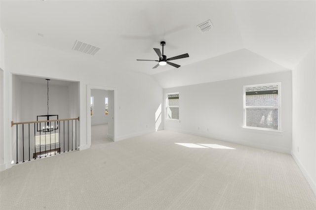 empty room featuring carpet floors, visible vents, and vaulted ceiling
