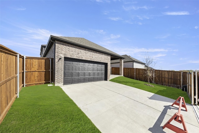view of side of home with driveway, roof with shingles, an attached garage, a yard, and brick siding