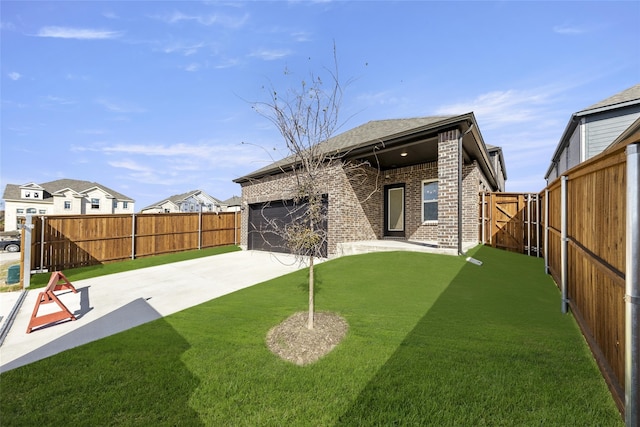 rear view of property with concrete driveway, a fenced backyard, a patio, and brick siding
